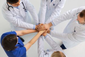 Group of doctors with hands together in a hospital
